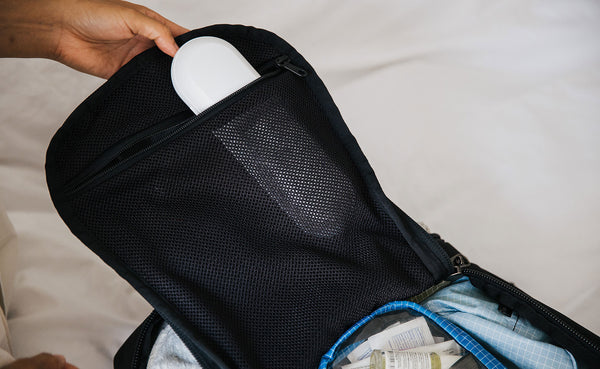 A person packing the mesh pocket on the lid of the Techonaut 30.